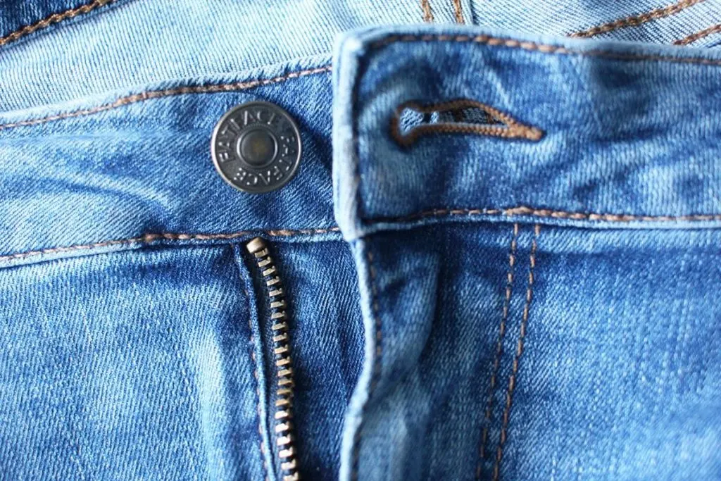 Close up photo of button and keyhole buttonhole on Fat Face jeans used to make a sewing pattern