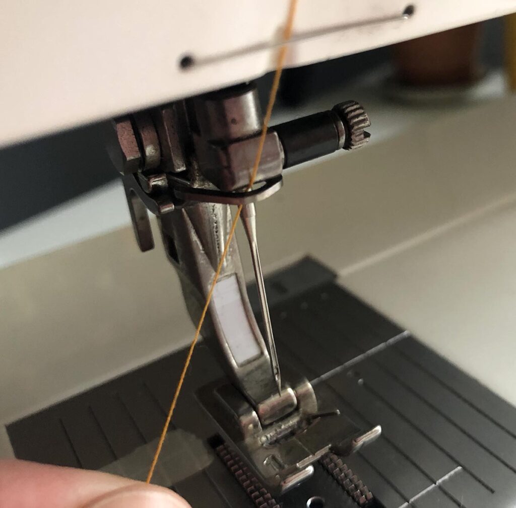 The thread is finally taken through the second of two wire guides when threading a Bernina 1008 sewing machine