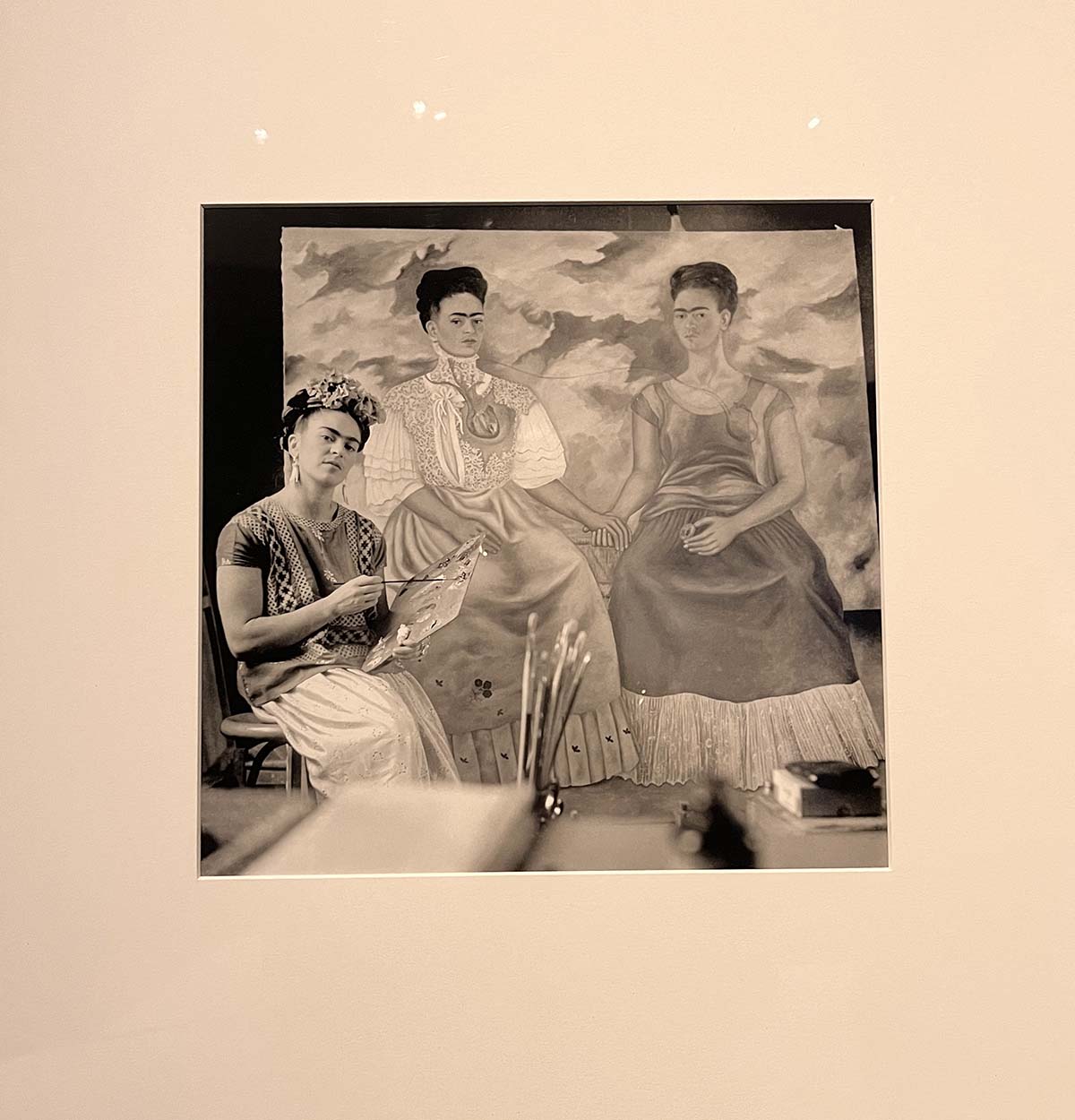 A photograph of Frida Kahlo with her 'Two Fridas' painting