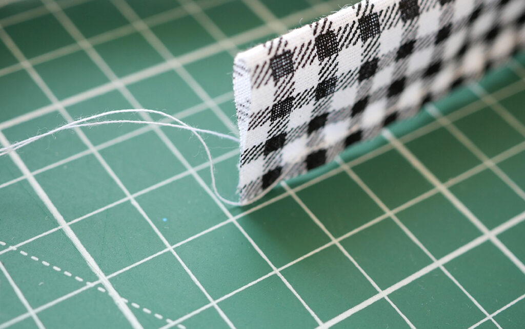 Leave long tails on both ends so that you can use them to gather the fabric evenly