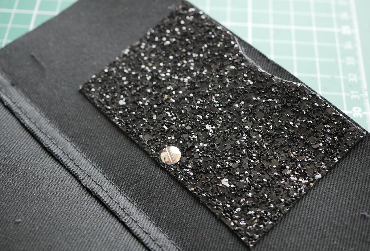 the back of the stud fastening is tightened with a screw driver so it can be removed and reused when the wallet has served its purpose