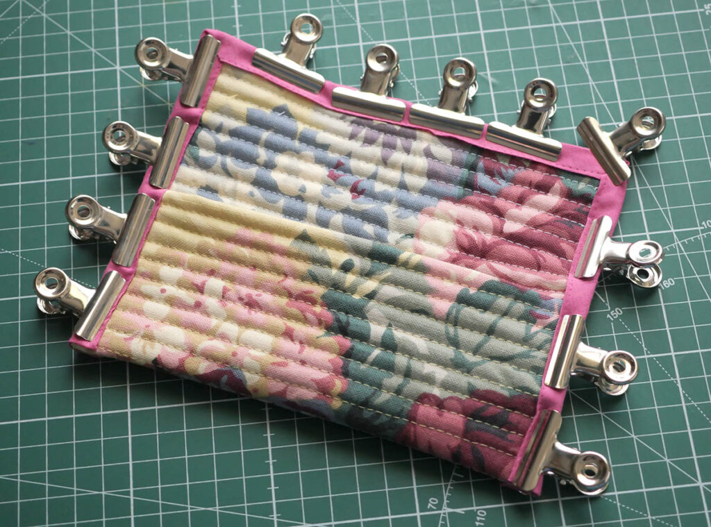 Holding the binding in place with clips before sewing