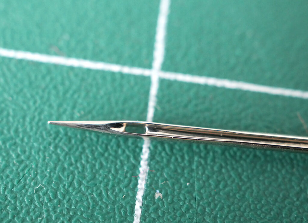 The scarf of the sewing machine needle is located right below the eye of the needle - in fact it often looks like it is part of the 'eye'.
