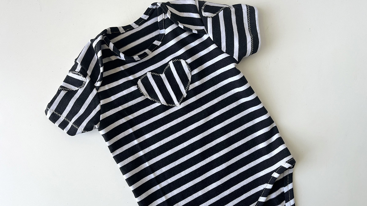 A newborn baby onesie in striped knit fabric