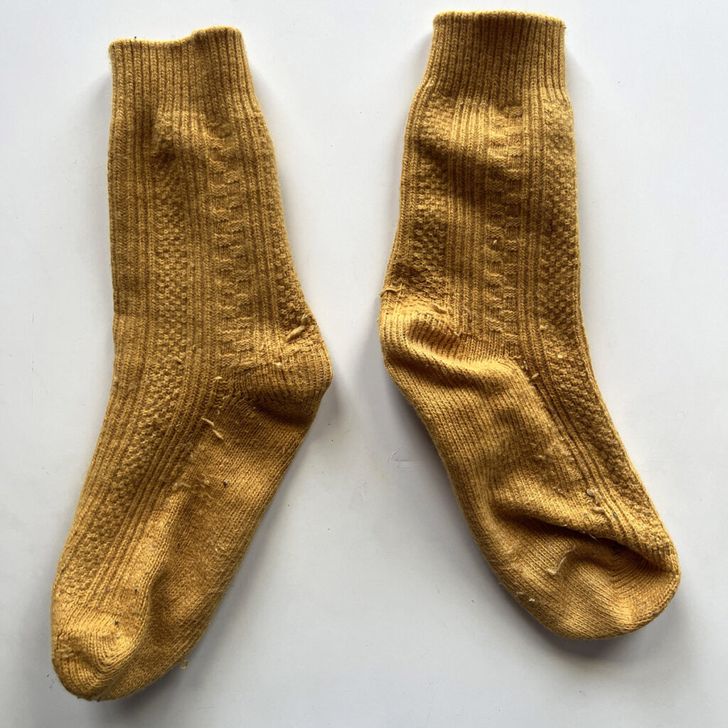 Yellow woollen socks on a white table top