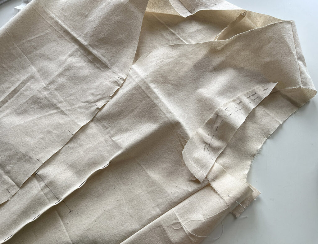 Pinning calico to 'fill in' the armhole he felt was missing on the waistcoat toile