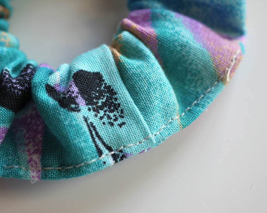 Close up detail of GWEN&SYD tropical turqois scrunchie