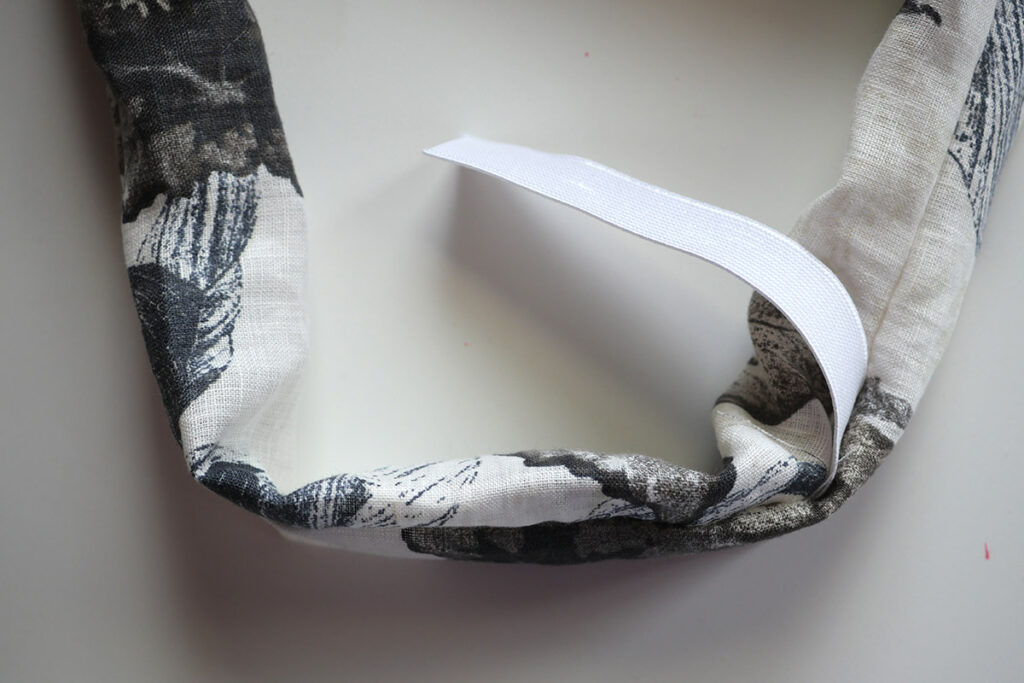 Feeding the wider elastic though the inside of the fabric tube using a bodkin