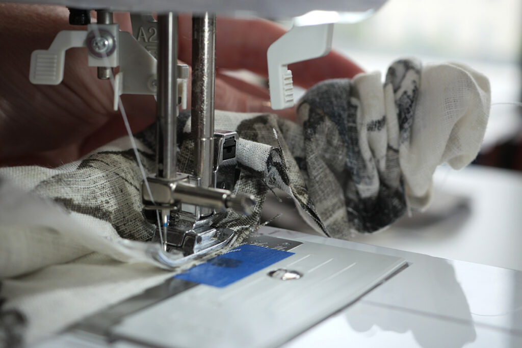 Gently pull the fabric through to continue sewing the burrito method
